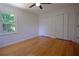 Bright bedroom featuring hardwood floors, a window with a view of trees, and a closet at 260 Lakemont Dr, Roswell, GA 30075