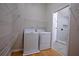 Well-organized laundry room featuring a washer and dryer next to a glass door shower at 260 Lakemont Dr, Roswell, GA 30075