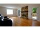 Cozy living room featuring a stone fireplace, hardwood floors, and a door to the outdoor deck at 260 Lakemont Dr, Roswell, GA 30075