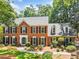 Elegant brick home featuring a symmetrical design, black shutters, and lush landscaping at 3506 Billingsley Dr, Marietta, GA 30062