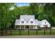 Beautiful two-story farmhouse with a welcoming front porch, lush landscaping, and mature trees surrounding the property at 2101 Thomas Rd, Canton, GA 30115