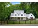 Stunning two-story farmhouse with a welcoming front porch and lush landscaping, framed by mature trees at 2101 Thomas Rd, Canton, GA 30115