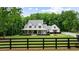 Charming two-story white farmhouse-style home with inviting porch, situated on sprawling green acreage at 2101 Thomas Rd, Canton, GA 30115