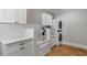 Well-appointed laundry room featuring white cabinetry, a dog washing station, and modern appliances at 2101 Thomas Rd, Canton, GA 30115