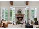 Cozy living room with a brick fireplace and views of the outdoor scenery through large windows at 2101 Thomas Rd, Canton, GA 30115