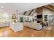 Spacious open-concept living room with modern kitchen, brick fireplace, and exposed wood beams at 2101 Thomas Rd, Canton, GA 30115