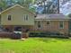 Spacious backyard featuring a brick patio, lush green grass, mature trees, and brick exterior of the house at 4094 Carlisle Pl, Stone Mountain, GA 30083