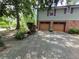 Two-car garage featuring brickwork, brown doors, and a paved driveway at 4094 Carlisle Pl, Stone Mountain, GA 30083