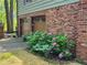 Two-car garage exterior showcasing brickwork, brown doors, and hydrangea bushes at 4094 Carlisle Pl, Stone Mountain, GA 30083