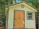 Outdoor shed with a gable roof, light-green siding and double doors at 4094 Carlisle Pl, Stone Mountain, GA 30083