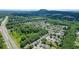 An expansive aerial view showing a residential neighborhood with mature trees near a highway and green fields at 4003 Coachman Ct, Cumming, GA 30040