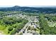 An aerial view of a lush, green residential community with mountain views and well-maintained single-Gathering homes at 4003 Coachman Ct, Cumming, GA 30040