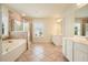 Bright bathroom featuring double sinks, a soaking tub, and a separate shower with tile surround at 4003 Coachman Ct, Cumming, GA 30040