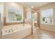 Well-lit bathroom featuring a soaking tub, tiled flooring, and a glass-door shower at 4003 Coachman Ct, Cumming, GA 30040