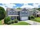 Beautiful home with a manicured lawn, lush greenery, and a two-car garage at 4003 Coachman Ct, Cumming, GA 30040