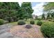 A stone-lined fire pit sits amidst manicured landscaping, creating an inviting outdoor gathering spot at 4003 Coachman Ct, Cumming, GA 30040