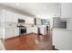 Open concept kitchen with hardwood floors, stainless steel appliances, and a view into the living area at 4003 Coachman Ct, Cumming, GA 30040