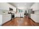 Modern kitchen featuring stainless steel appliances, white cabinetry, hardwood flooring and an open layout at 4003 Coachman Ct, Cumming, GA 30040