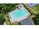 Aerial view of community pool with seating and umbrellas, alongside tennis courts at 4003 Coachman Ct, Cumming, GA 30040