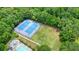 An aerial view of well-maintained tennis courts next to a community pool and a serene, wooded area at 4003 Coachman Ct, Cumming, GA 30040