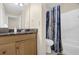 Bright bathroom features a wood vanity, granite countertop, and shower with decorative blue curtain at 4081 Riverlook Se Pkwy # 13, Marietta, GA 30067