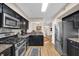 Galley kitchen featuring black cabinets, granite countertops, and stainless steel appliances at 4081 Riverlook Se Pkwy # 13, Marietta, GA 30067