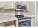 Modern kitchen featuring stainless steel appliances, white cabinets, and beautiful countertops at 440 Forestgate Ct, Atlanta, GA 30350