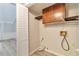 Laundry room featuring overhead cabinets and shelving in need of repair at 440 Forestgate Ct, Atlanta, GA 30350