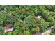 An aerial view depicts the property lines encompassing a verdant, tree-filled landscape at 980 Hightower Trl, Sandy Springs, GA 30350