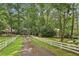 A picturesque view features a red brick home with a white picket fence and tree lined driveway at 980 Hightower Trl, Sandy Springs, GA 30350