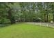 Expansive front yard with lush green grass and a classic white picket fence leading up to the home at 980 Hightower Trl, Sandy Springs, GA 30350