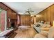 Cozy living room featuring a brick fireplace, wood paneling, and lots of natural light at 980 Hightower Trl, Sandy Springs, GA 30350