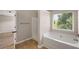 A bathtub sits below a window providing natural light in this bathroom at 1212 Ithaca Dr, Mcdonough, GA 30253