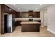 Well-equipped kitchen featuring dark wood cabinetry, an island and stainless steel appliances at 1212 Ithaca Dr, Mcdonough, GA 30253