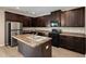 Modern kitchen with dark wood cabinets, central island, and stainless steel refrigerator at 1212 Ithaca Dr, Mcdonough, GA 30253