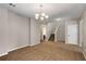 Open living area with neutral carpet, a stylish chandelier, and convenient access to the staircase at 1212 Ithaca Dr, Mcdonough, GA 30253