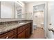 Bathroom with granite countertop, wood cabinets, and tiled shower with glass door at 1481 Bentley Se Ln, Marietta, GA 30067