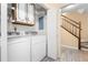Laundry area adjacent to the staircase with washer, dryer and upper cabinets at 1481 Bentley Se Ln, Marietta, GA 30067
