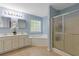 Bright blue bathroom featuring a double sink vanity, a soaking tub, and a glass-enclosed shower at 722 Ivory Trl, Woodstock, GA 30188