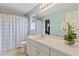 Light and airy bathroom with white vanity, framed mirror, and a shower/tub combo with a patterned curtain at 722 Ivory Trl, Woodstock, GA 30188