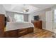 Spacious bedroom featuring wood-look floors, tray ceilings, a dresser, and an ensuite bathroom at 722 Ivory Trl, Woodstock, GA 30188