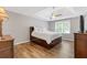 A well-lit bedroom with tray ceilings, wood-look floors, and a bed with storage drawers underneath at 722 Ivory Trl, Woodstock, GA 30188
