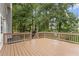 Outdoor wooden deck with stairs leading to a fenced backyard surrounded by mature trees at 722 Ivory Trl, Woodstock, GA 30188