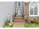 Inviting front entrance with stone accents, flowering plants and a charming covered porch at 722 Ivory Trl, Woodstock, GA 30188