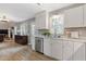 Sunlit kitchen with white cabinets, stainless appliances, and open view of living room at 722 Ivory Trl, Woodstock, GA 30188