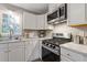 Well lit kitchen offers white cabinets, stainless appliances and modern fixtures at 722 Ivory Trl, Woodstock, GA 30188