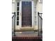 Close-up of front door with sidelights, iron railing, and brick steps, offering a warm and inviting entry at 974 Bloomfield Dr, Lawrenceville, GA 30044