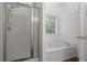 Bright bathroom featuring a soaking tub, glass shower, and natural light at 1048 Falls Brooke Dr, Conyers, GA 30094