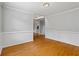 Spacious living room with hardwood floors, white walls, and a view of the staircase at 1048 Falls Brooke Dr, Conyers, GA 30094