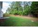 Spacious backyard features a fenced-in yard and mature trees, providing privacy and shade at 1137 Misty Valley Ct, Lawrenceville, GA 30045